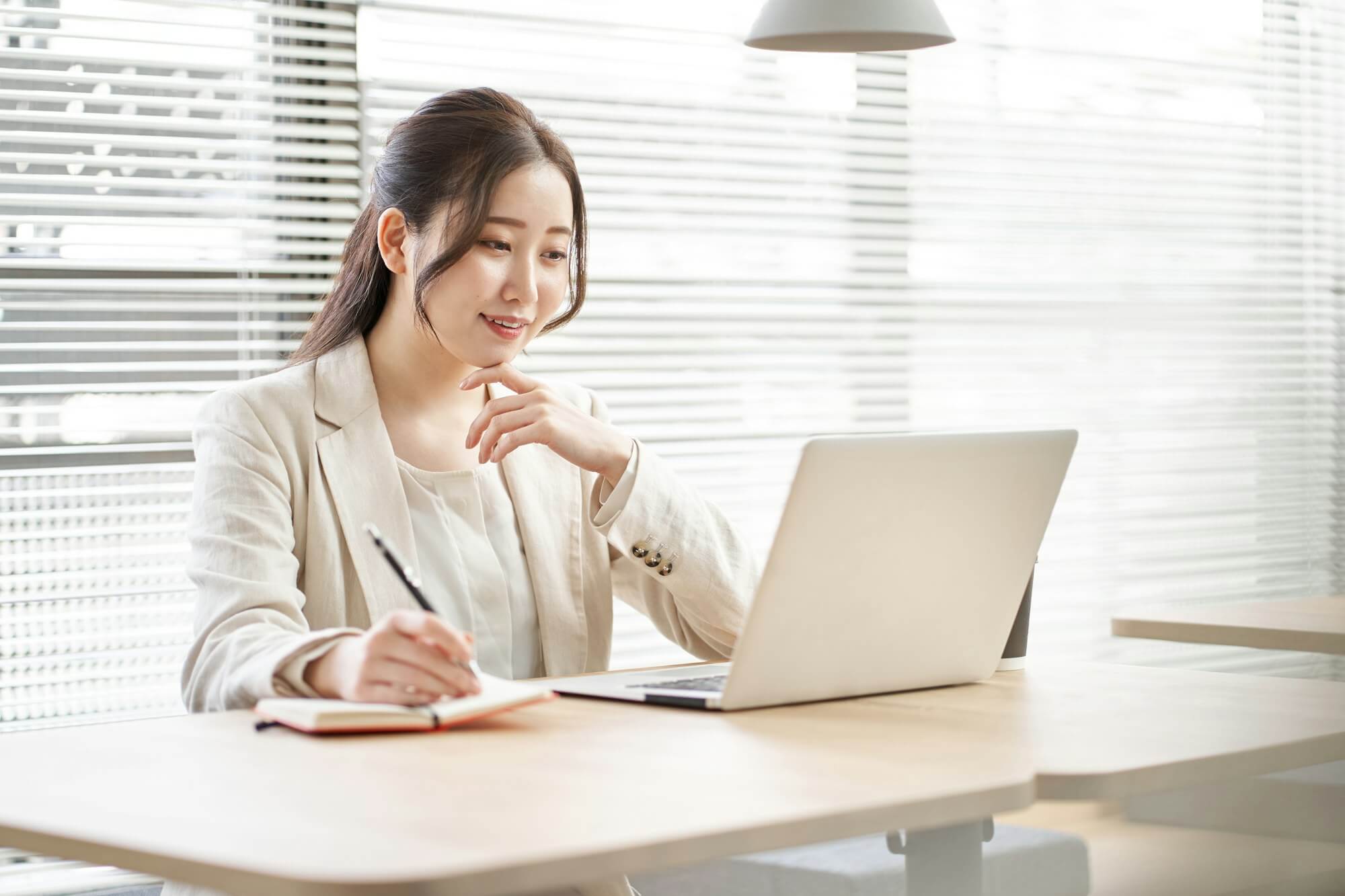 Asian woman taking notes in a coworking space