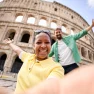 happy-couple-taking-a-selfie-in-front-of-the-colos-SXHXFPY